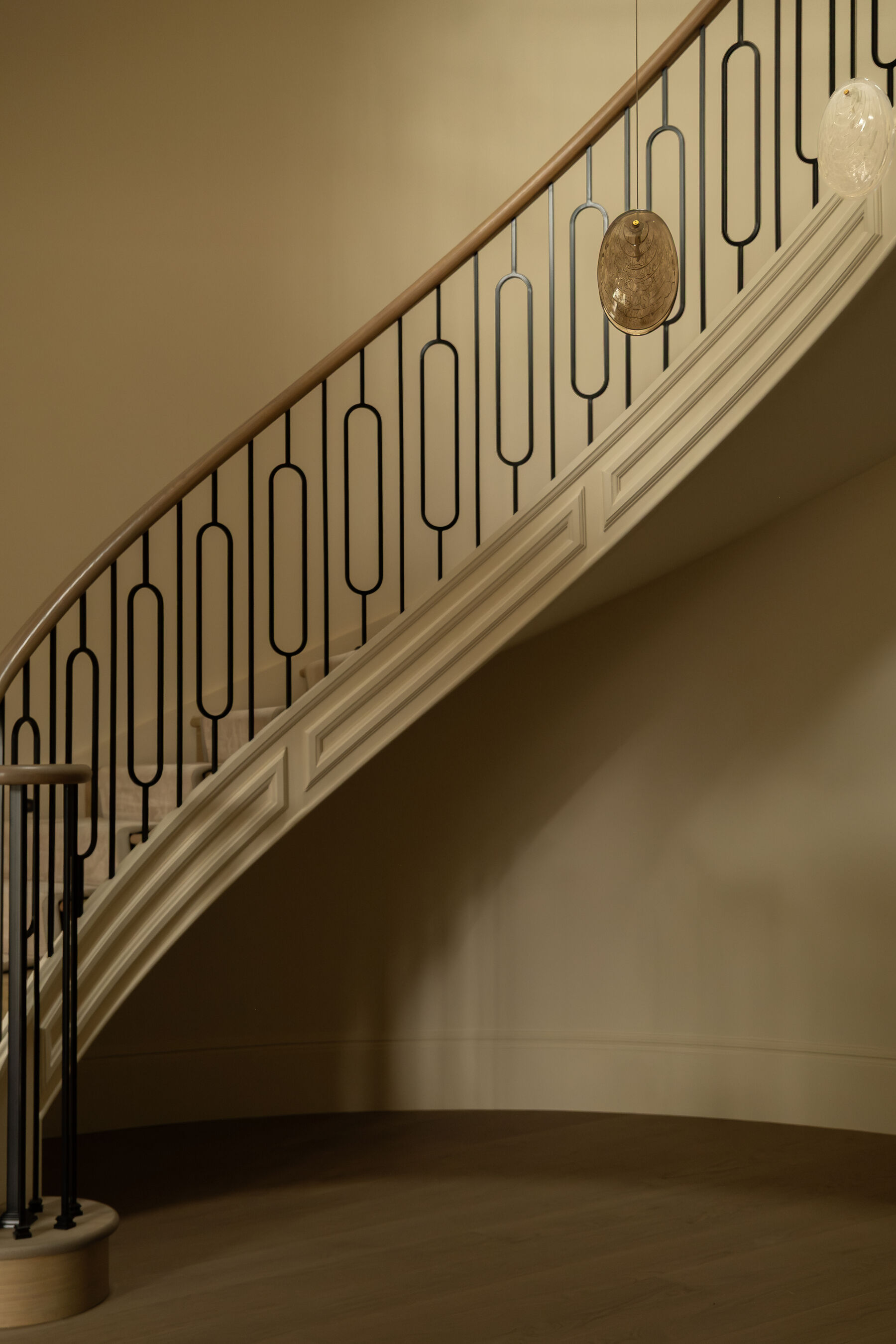 Curved staircase with slender ironwork balustrade